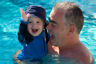Dad and baby swimming in pool
